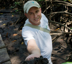 Smithsonian ecologist Pat Megonigal holds up a handful of soil from a wetland in Costa Rica. (Sarah Hoyt/Conservation International)