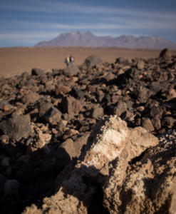Atacama Desert landscape with a colonized Gypsum rock in the foreground.
