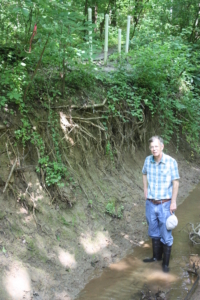 Tom Jordan standing in Muddy Creek, an eroded stream at SERC, before it was restored.